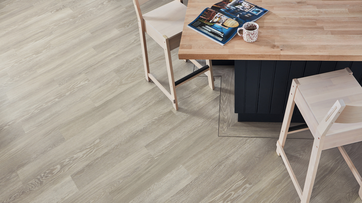 Overhead of a kitchen island framed by Charcoal DS16 3mm design strips on a Grey Limed Oak KP138 floor