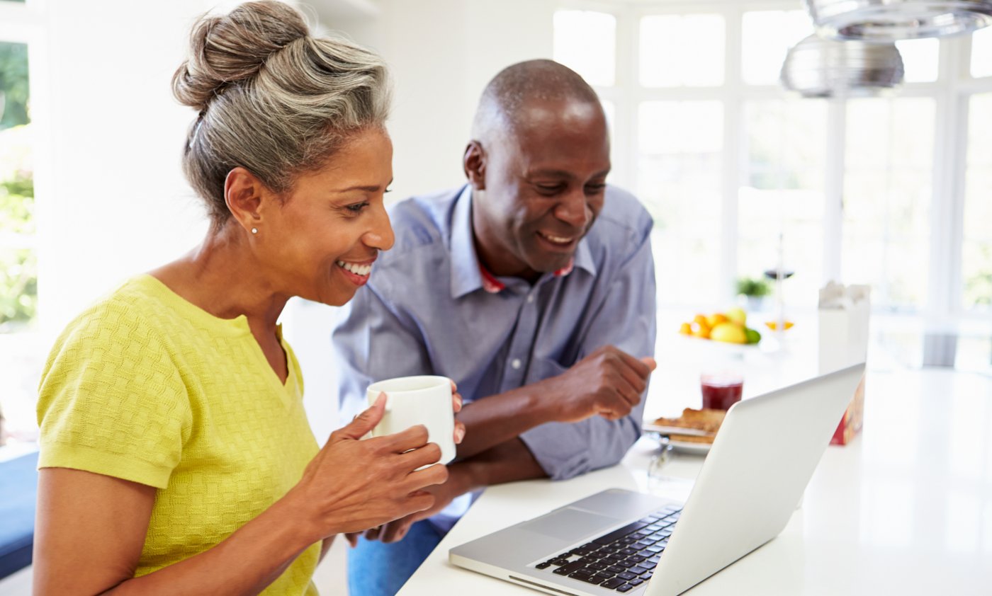 Older couple looking at a laptop in their kitchen